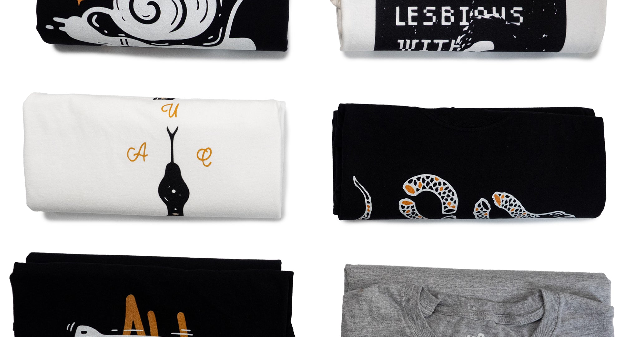 Collection of folded AUC heavyweight shirts with various designs on a white background